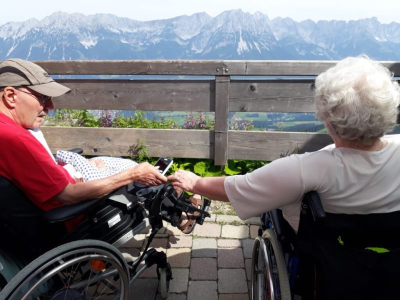 Zwei Rollstuhlfahrer vor dem Alpenpanorama in Tirol